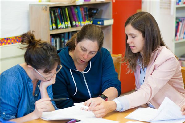 Three teachers discussing materials - The Lesson Study Group